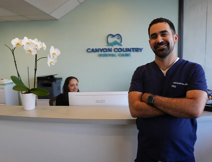 Dr. Dabirian welcoming a new patient at the front desk of Canyon Country Dental Care