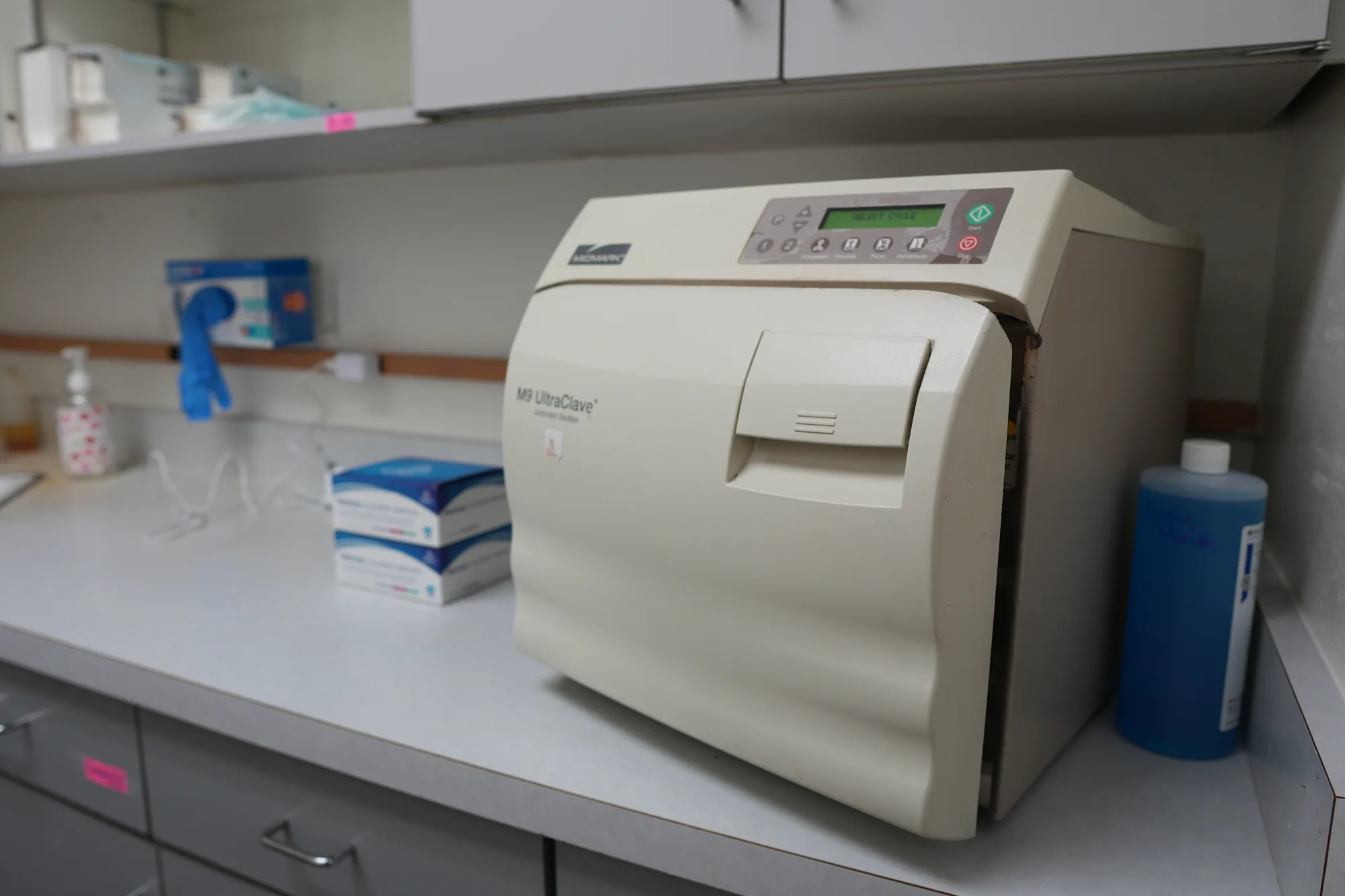 Autoclave sterilizer on a counter in the sterilization area, with supplies beside it