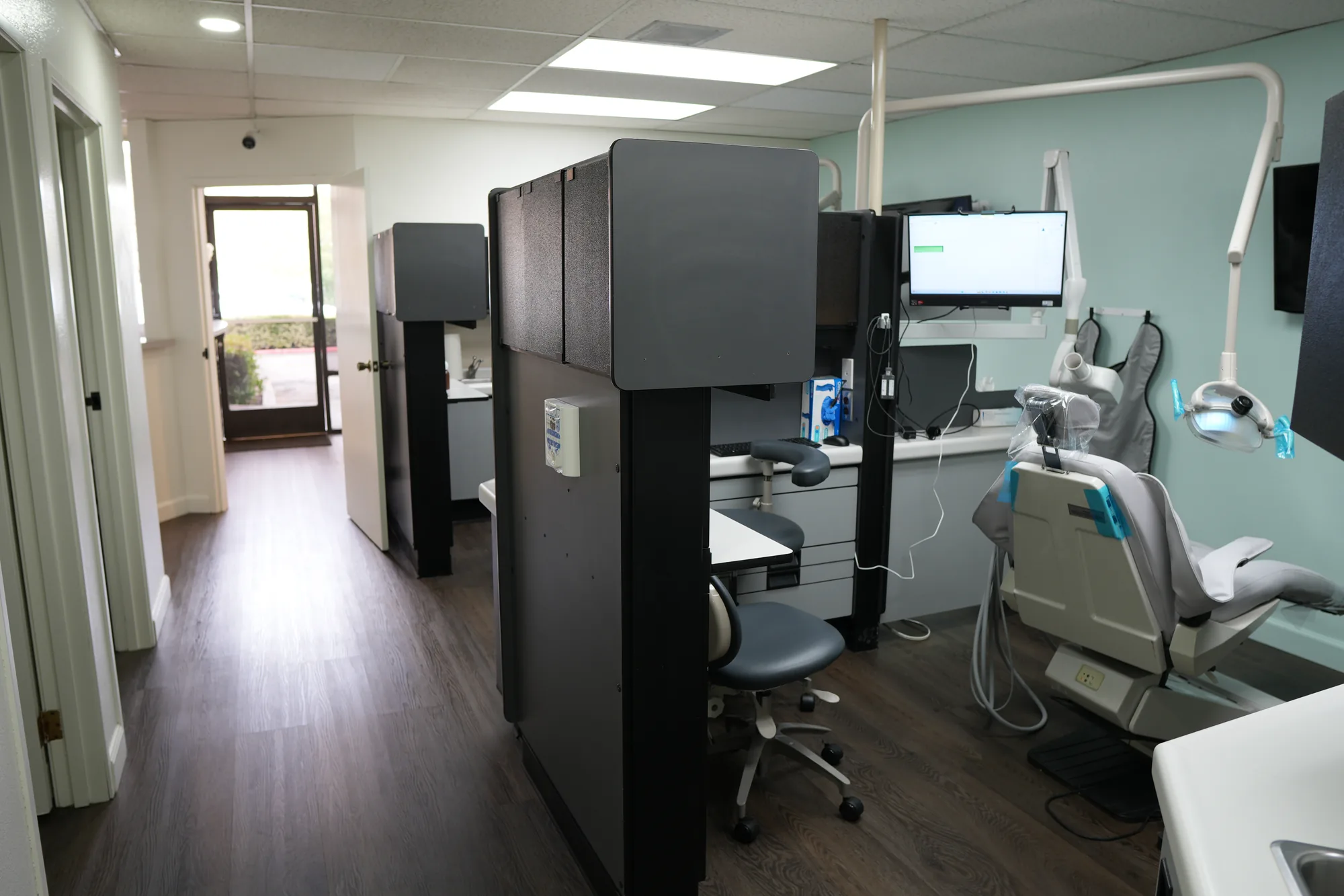 A treatment room at Canyon Country Dental Care with a dental chair, monitor and overhead light