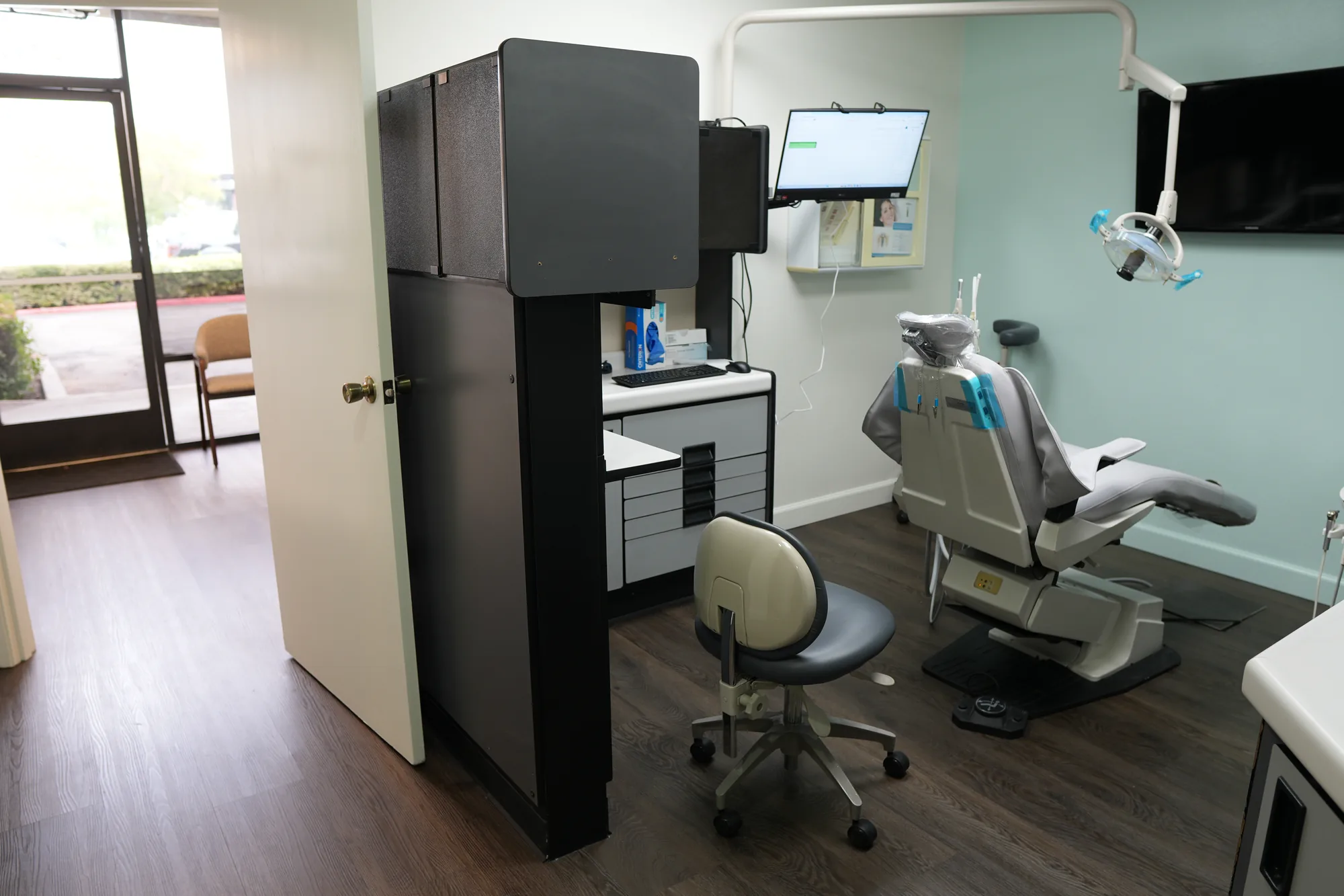 A treatment room at Canyon Country Dental Care with a dental chair, monitor and overhead light
