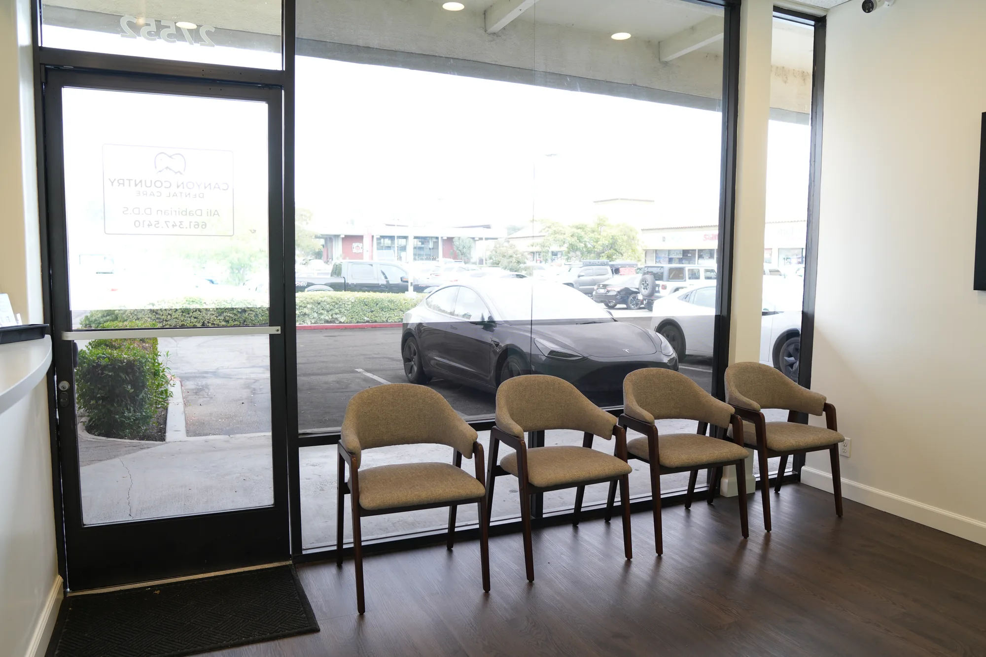 Waiting area just inside the glass entrance door, with chairs along the window